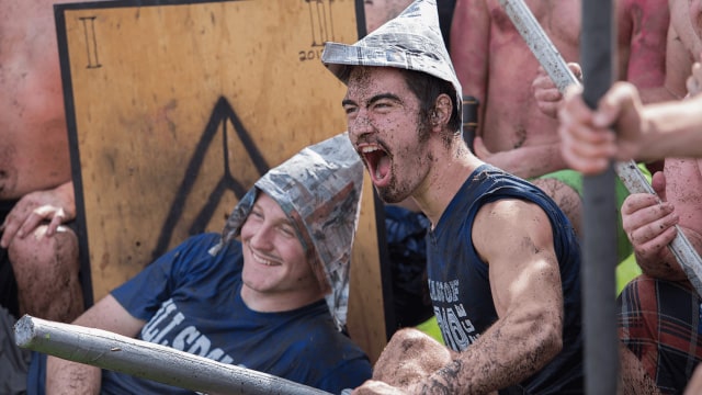 Muddied students with duct tape weapons and shields after the annual Naval Battle.