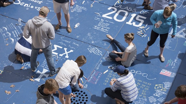 Seniors writing in chalk on campus sidewalks.