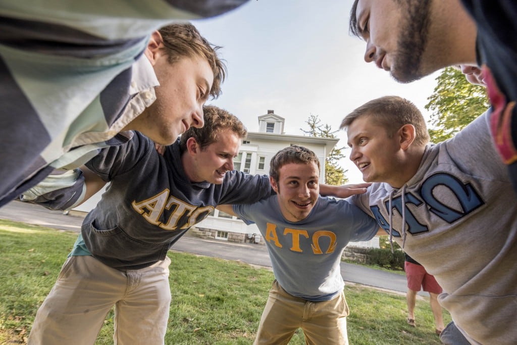 Alpha Tau Omega group huddle outside the fraternity house.